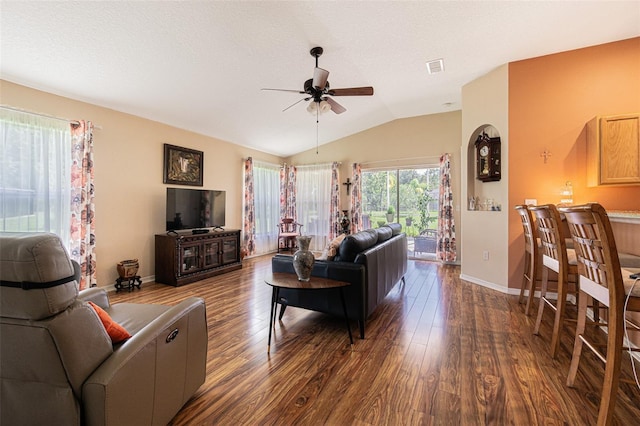 living room featuring lofted ceiling, visible vents, a ceiling fan, wood finished floors, and baseboards