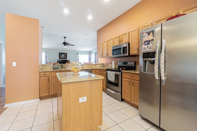 kitchen featuring a kitchen island, light stone counters, a peninsula, stainless steel appliances, and light tile patterned flooring