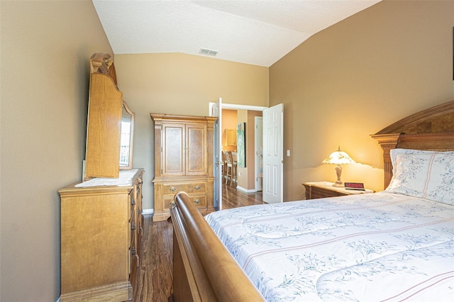 bedroom featuring lofted ceiling, dark wood finished floors, visible vents, and baseboards