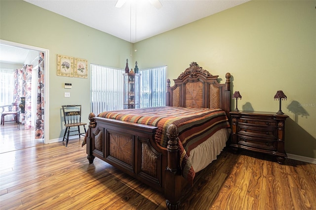 bedroom featuring a ceiling fan, baseboards, and wood finished floors