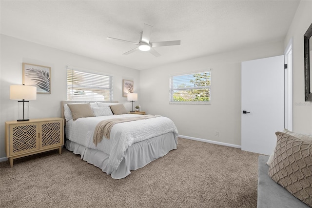 carpeted bedroom featuring multiple windows, baseboards, and ceiling fan