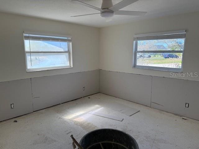 unfurnished room with a wealth of natural light and ceiling fan