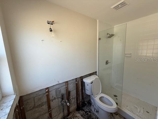 bathroom featuring toilet, visible vents, and a stall shower