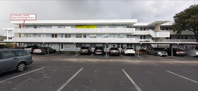 view of property featuring covered and uncovered parking