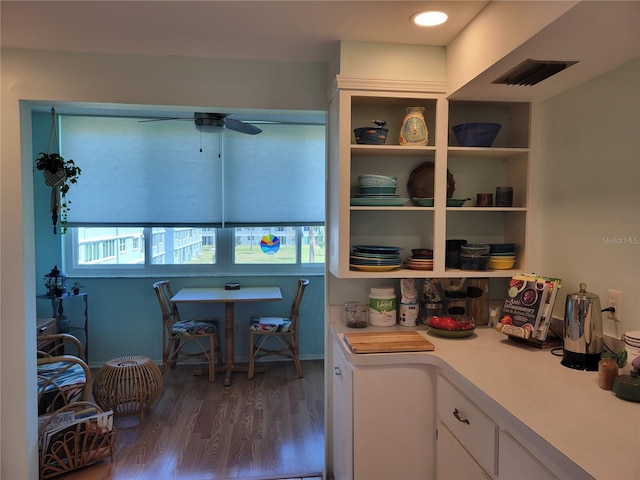 interior space with visible vents, white cabinets, wood finished floors, light countertops, and open shelves