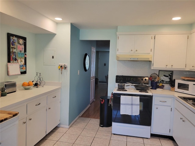 kitchen featuring light tile patterned floors, white microwave, under cabinet range hood, decorative backsplash, and electric range oven