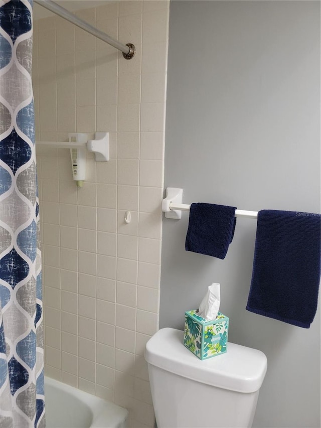 bathroom featuring toilet and shower / bath combination with curtain