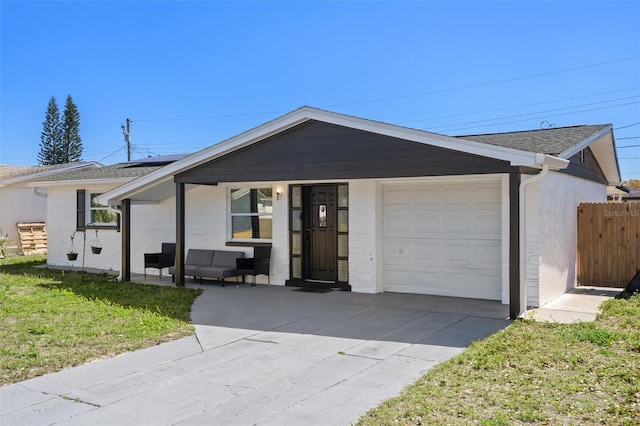 ranch-style home with an attached garage, fence, driveway, and an outdoor hangout area