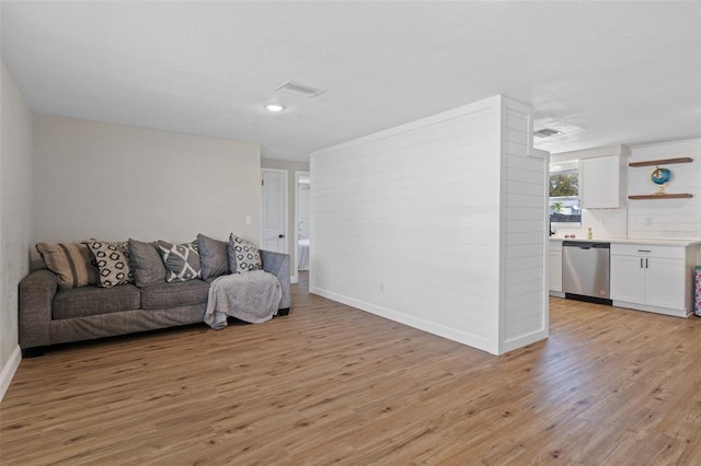 living room featuring visible vents, baseboards, and light wood-style floors