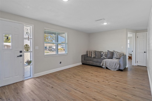 entryway with light wood finished floors, visible vents, and baseboards