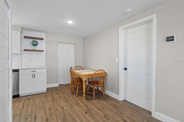 dining area featuring baseboards and light wood finished floors