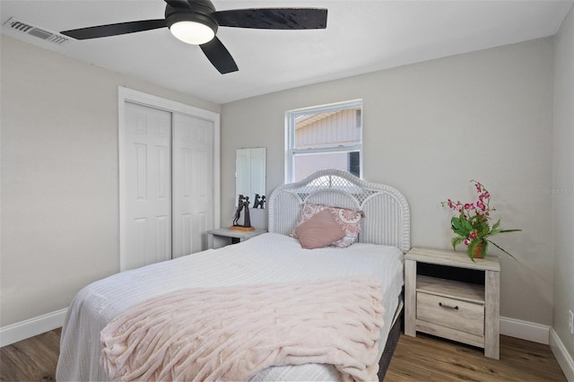 bedroom featuring a closet, visible vents, baseboards, and wood finished floors