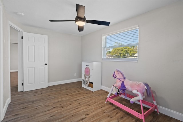 playroom with ceiling fan, baseboards, and wood finished floors