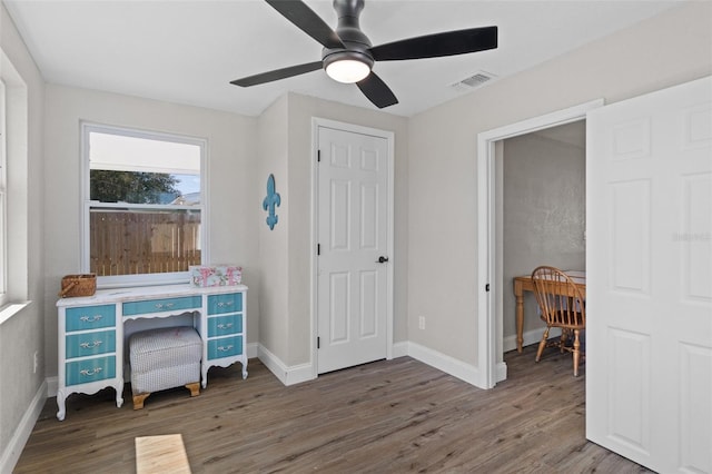 home office with visible vents, ceiling fan, baseboards, and wood finished floors