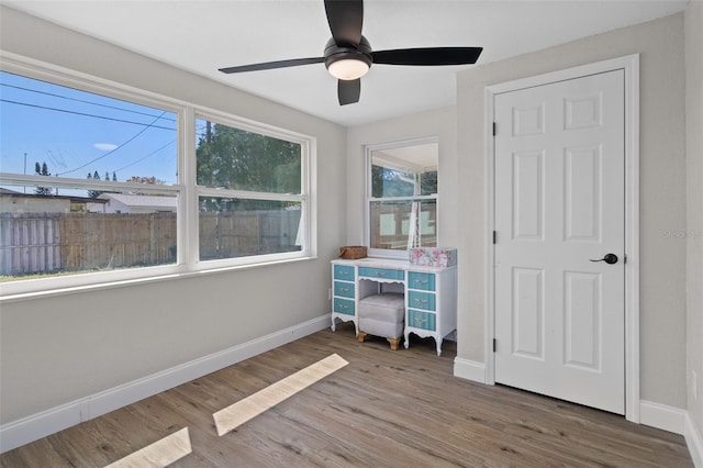 bedroom featuring ceiling fan, baseboards, and wood finished floors