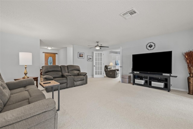 carpeted living area with visible vents, baseboards, french doors, a textured ceiling, and a ceiling fan