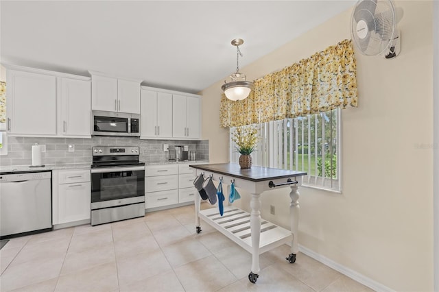 kitchen featuring decorative backsplash, white cabinets, light tile patterned flooring, and appliances with stainless steel finishes