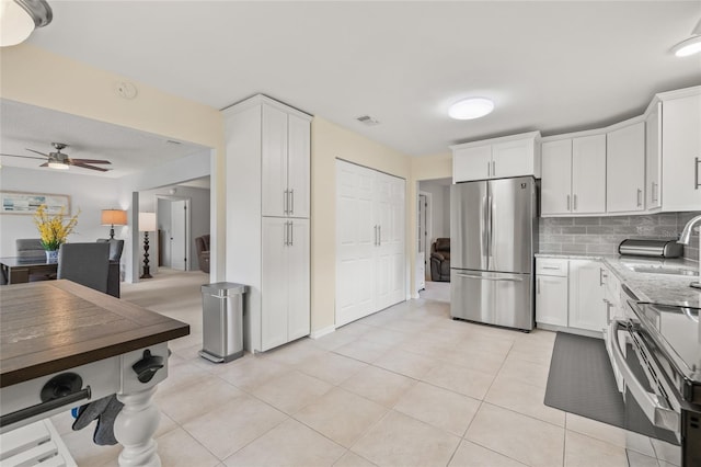 kitchen with decorative backsplash, appliances with stainless steel finishes, and white cabinetry