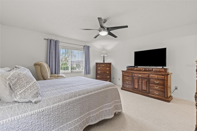 carpeted bedroom featuring a ceiling fan and a textured ceiling