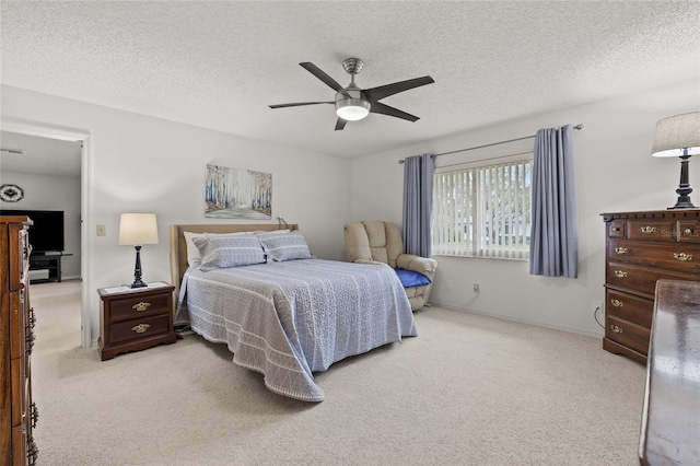 carpeted bedroom featuring a textured ceiling and ceiling fan