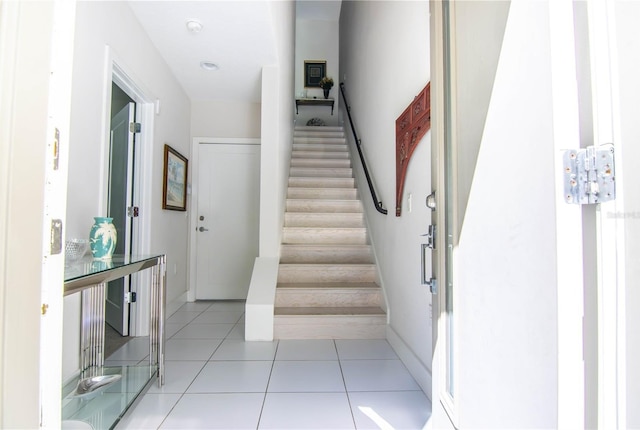 staircase with baseboards and tile patterned floors