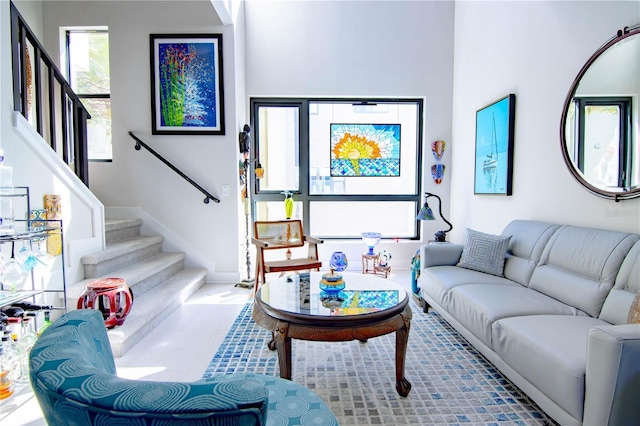 living room featuring stairs and baseboards