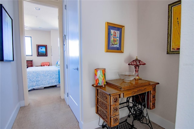 corridor featuring light carpet and baseboards