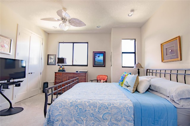 bedroom with carpet floors, a textured ceiling, multiple windows, and a ceiling fan