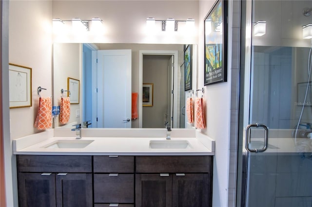 full bath featuring double vanity, a shower stall, and a sink