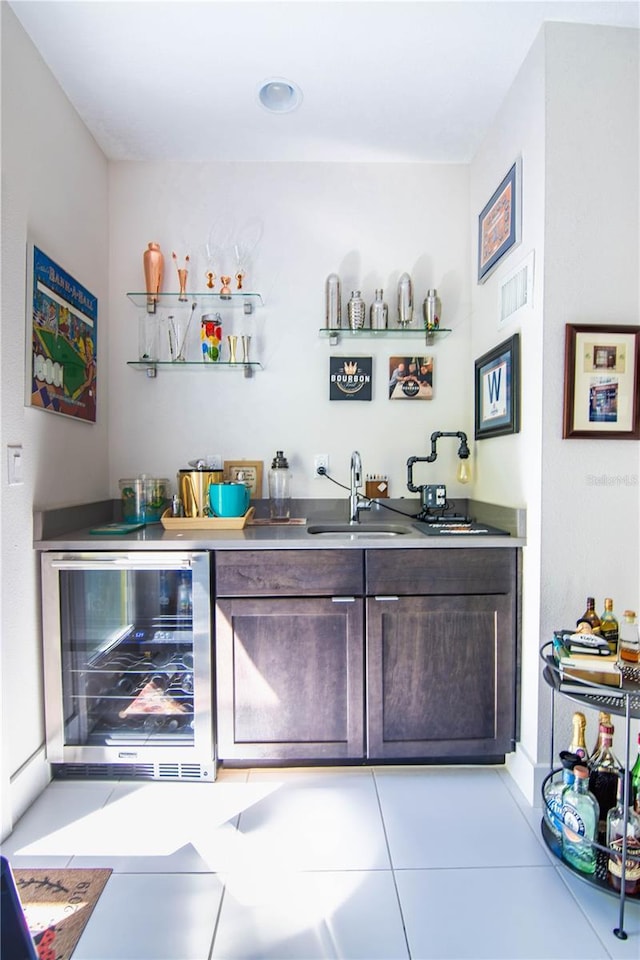 bar with light tile patterned floors, wine cooler, a sink, visible vents, and indoor wet bar