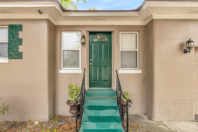 entrance to property featuring stucco siding