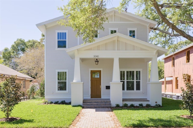 view of front of home featuring a porch, a front yard, and board and batten siding