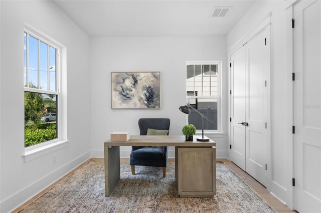 office area featuring baseboards, visible vents, and light wood-style flooring