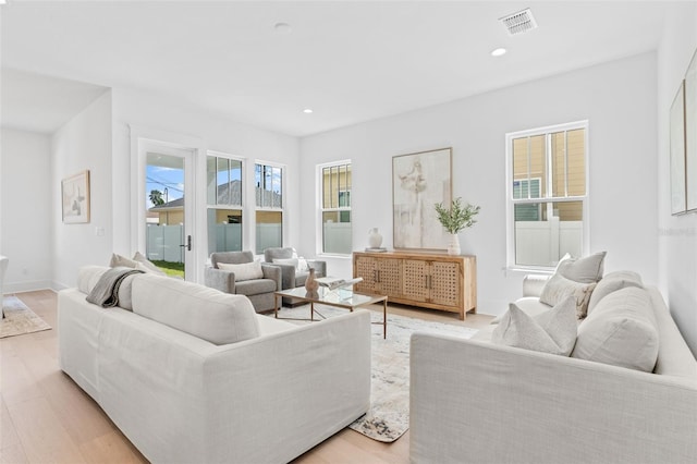 living area featuring recessed lighting, visible vents, light wood-style flooring, and baseboards