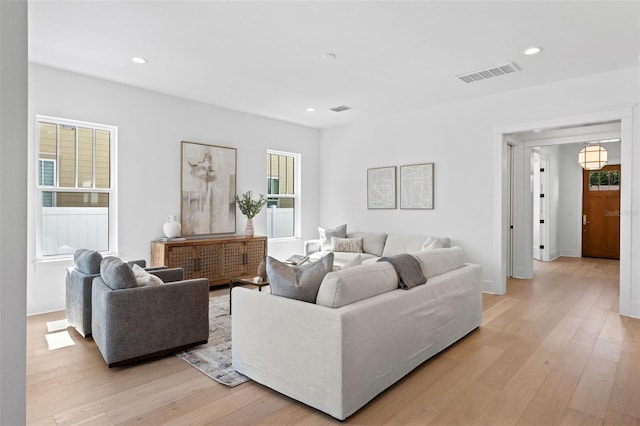 living room featuring light wood-style floors, visible vents, and recessed lighting