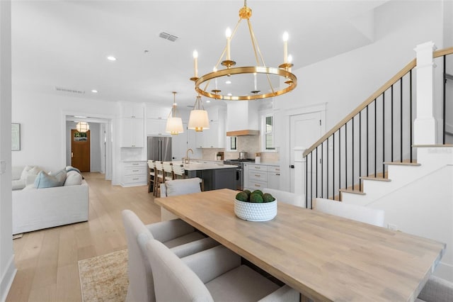 dining room with light wood-style floors, stairs, visible vents, and recessed lighting