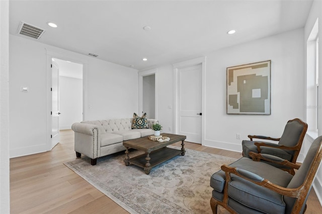 living area with light wood-style flooring, visible vents, and recessed lighting