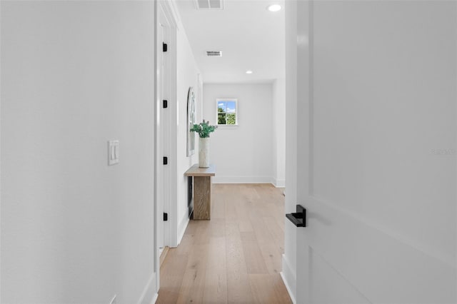 hallway featuring light wood-style floors, recessed lighting, visible vents, and baseboards