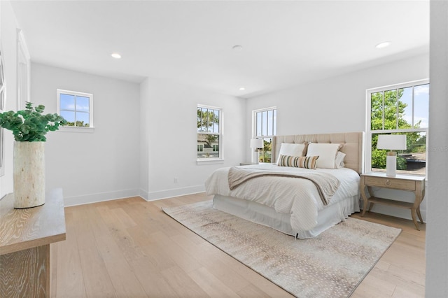 bedroom with light wood-type flooring, multiple windows, baseboards, and recessed lighting