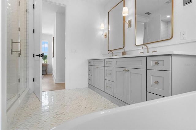 full bathroom featuring a stall shower, visible vents, a sink, and double vanity