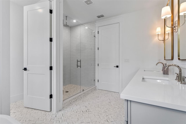 full bath featuring double vanity, a sink, visible vents, and a shower stall