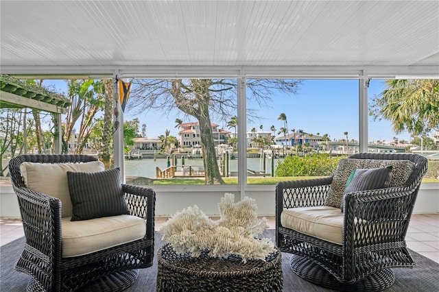 sunroom featuring a water view