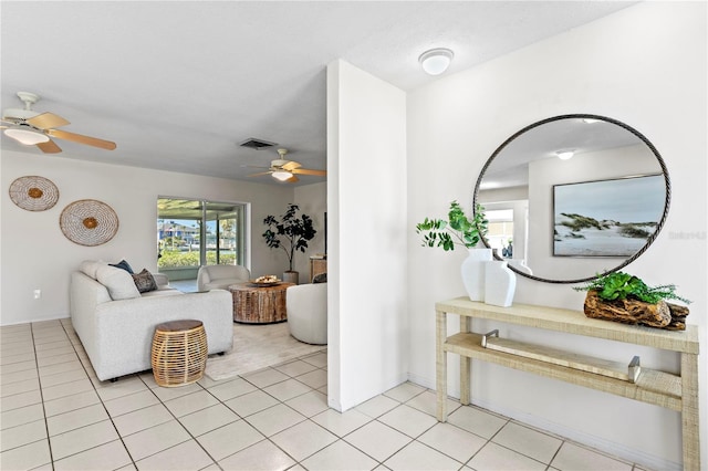 living area with visible vents, ceiling fan, baseboards, and light tile patterned floors