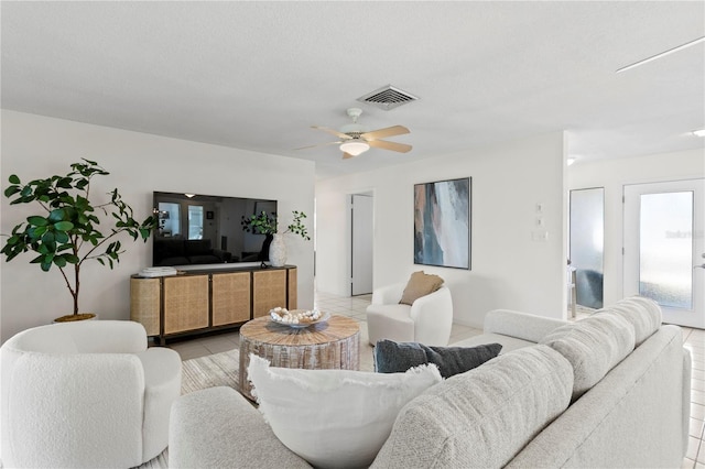 living room featuring visible vents, a ceiling fan, and light tile patterned flooring