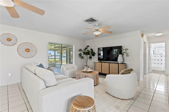 living area featuring light tile patterned floors, baseboards, visible vents, and a ceiling fan