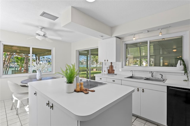 kitchen featuring light tile patterned floors, a sink, visible vents, light countertops, and black appliances