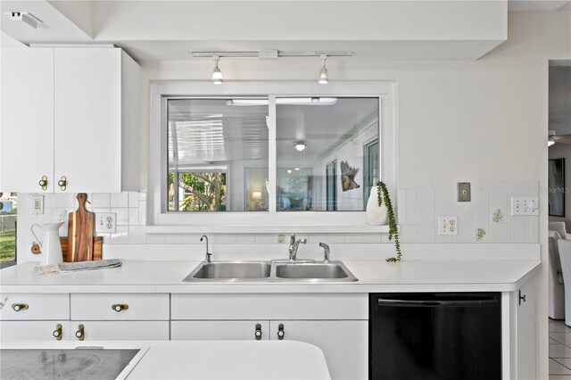 kitchen featuring dishwasher, light countertops, tasteful backsplash, and a sink