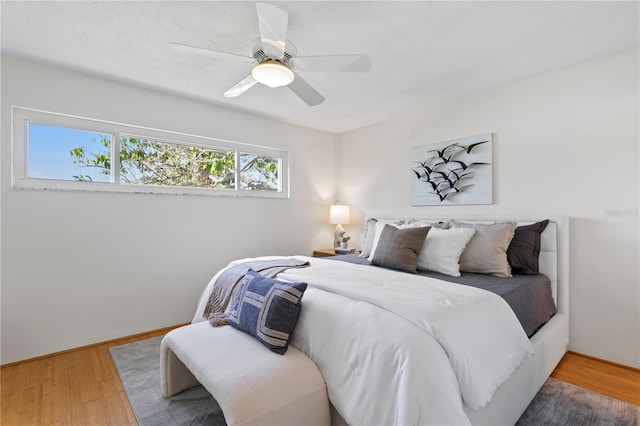 bedroom featuring light wood-style floors, ceiling fan, and baseboards