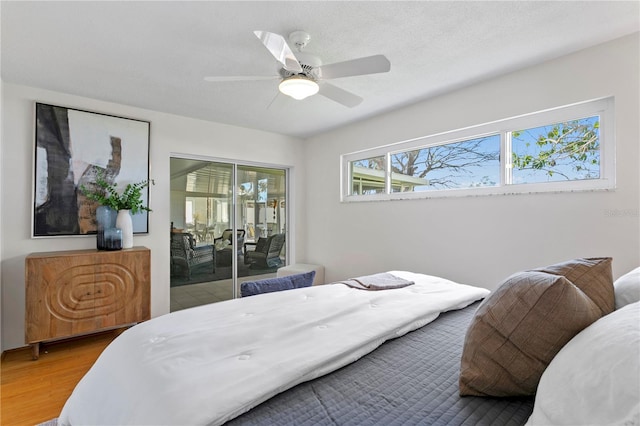 bedroom with access to outside, a ceiling fan, and wood finished floors