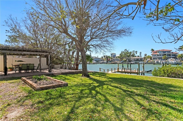 view of yard with a dock, a water view, boat lift, and a patio area